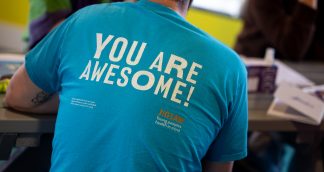 man wearing a blue tshirt that says you are awesome on the back
