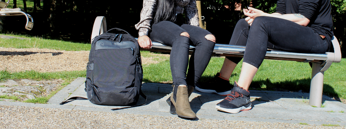 A image of two young people sitting on a bench talking
