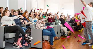 young people throwing paper airplanes