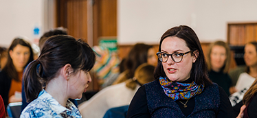 Picture of two women chatting in a crowd
