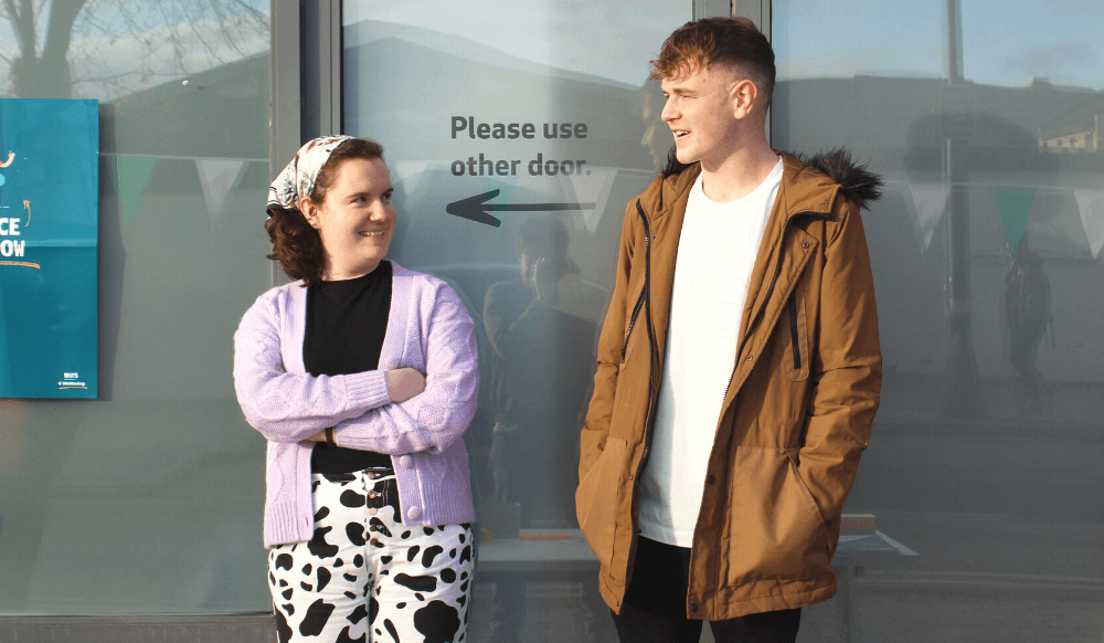 A young woman and young man chatting outside