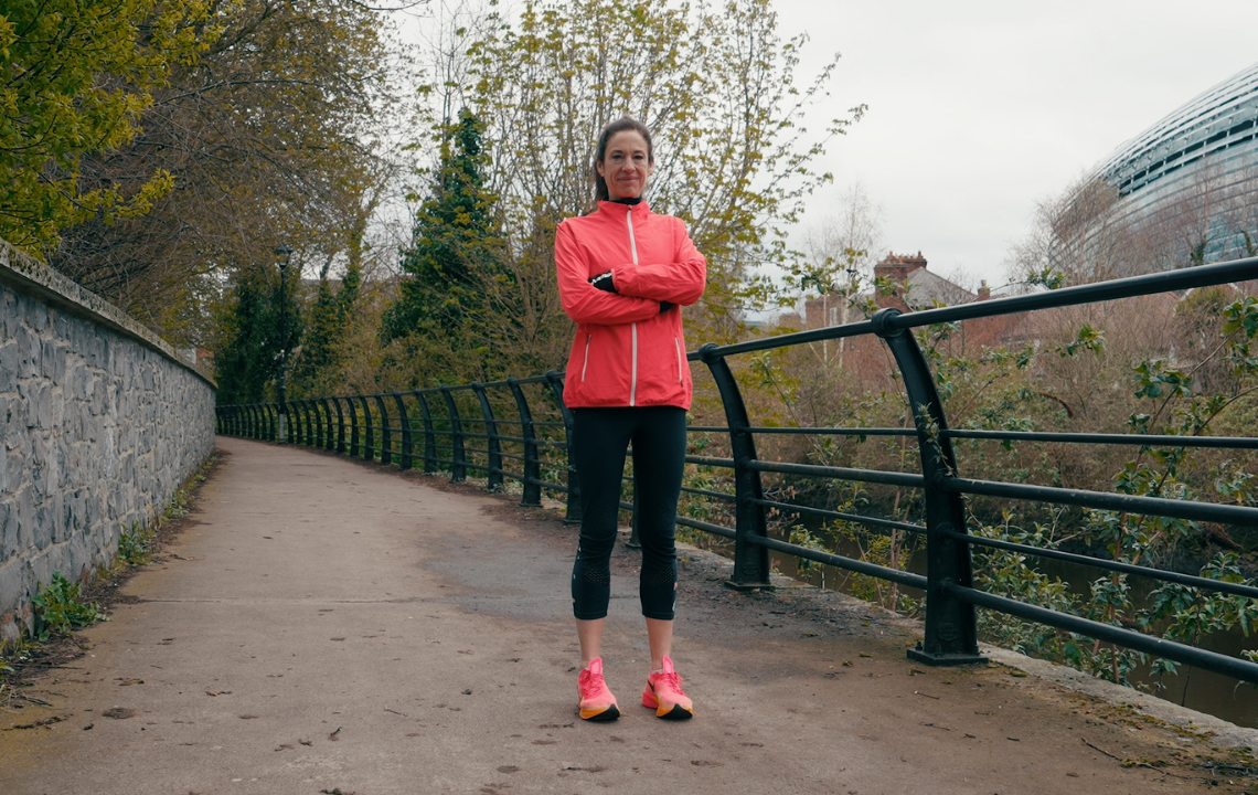 Venetia Quick in pink running jacket standing with her arms crossed