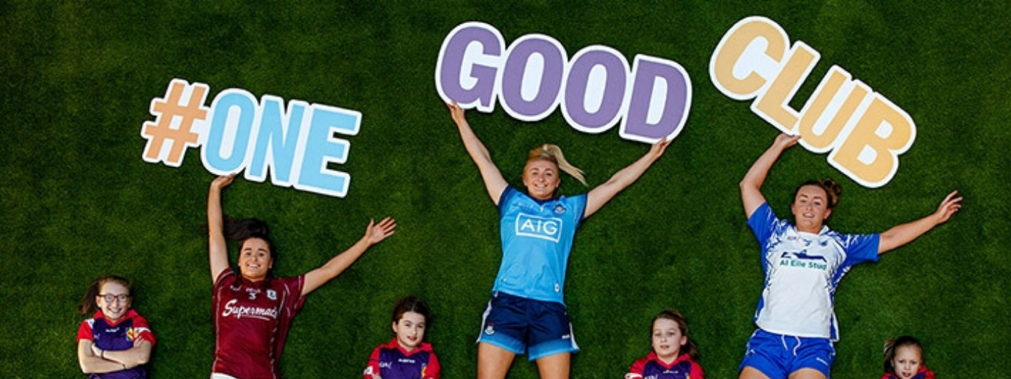 A close up of a computer keyboard, next to a notebook and cup of coffee